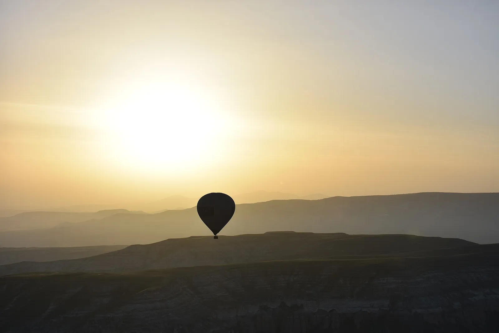 A hot air balloon above Cappadocia at sunrise