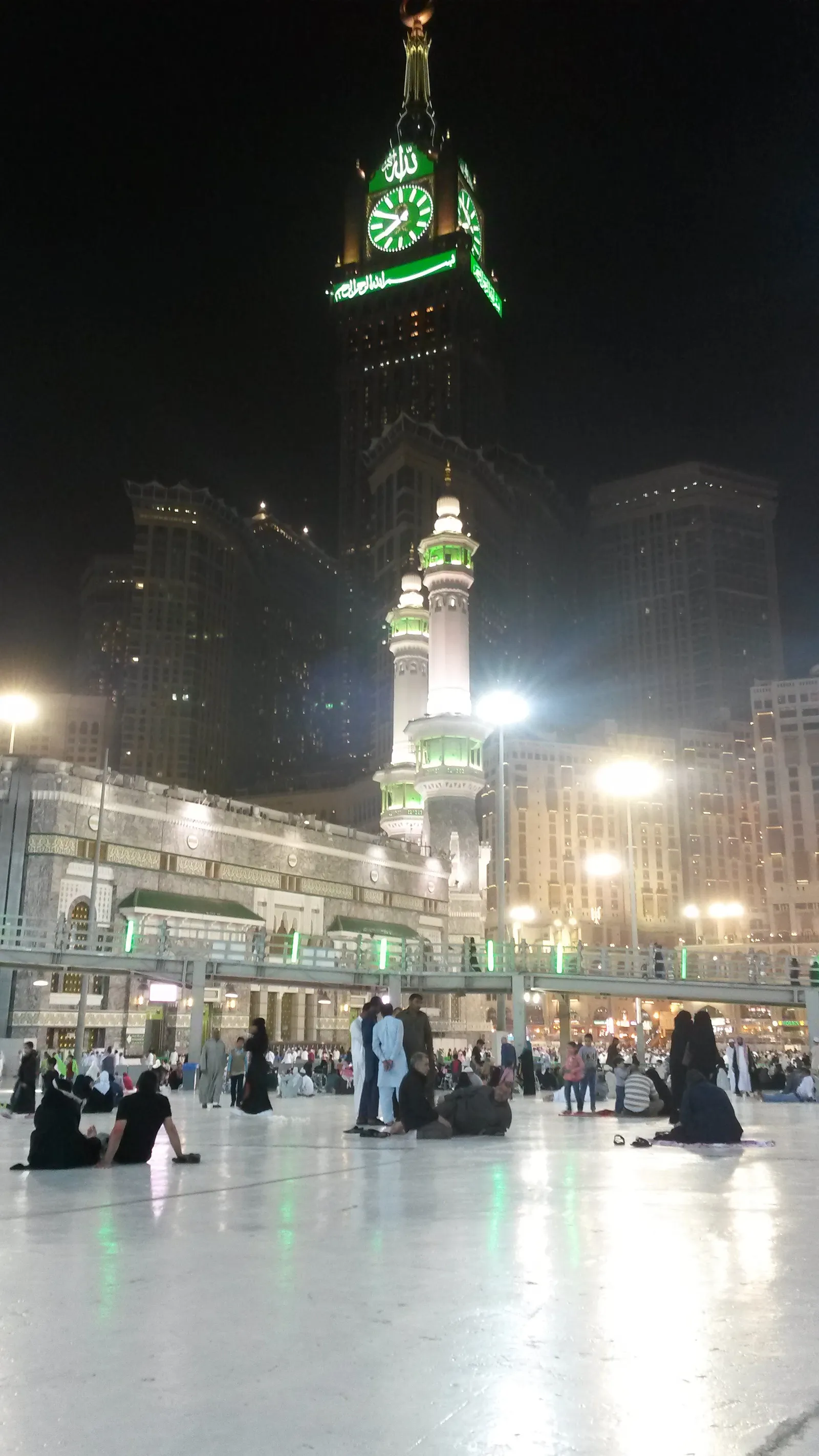 The Makkah clock tower lit at night above the Haram courtyard